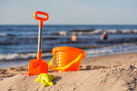 Orange beach toy set at sunny coastの写真素材