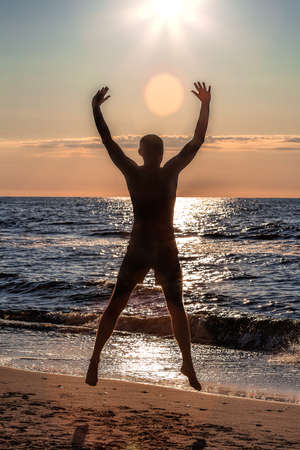 Energetic exercise on the beach at sunsetの写真素材