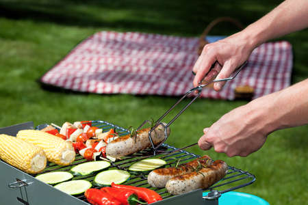 A man cooking food for a summer lunch in the gardenの写真素材
