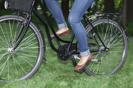 Young girl riding abike in the summery parkの写真素材