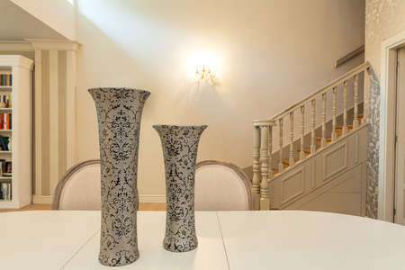 Vintage mansion - a closeupof two patterned vases on a cream tableの写真素材