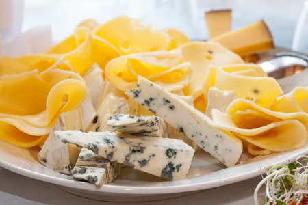 A close up of blue cheese pieces and yellow cheese slicesの写真素材