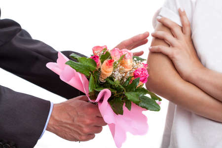 Man apologizing a women and giving her a bouquet of flowersの写真素材