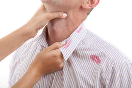 Woman strangling man with red lipstick kisses on his shirtの写真素材
