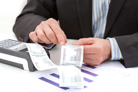 Man's hands analysing the expenses and a bar chartの写真素材