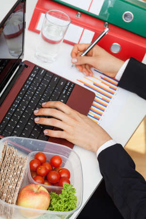 Young busy manager has no time for break at workの写真素材