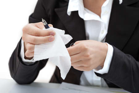 A woman cleaning a pen with a white tissueの写真素材