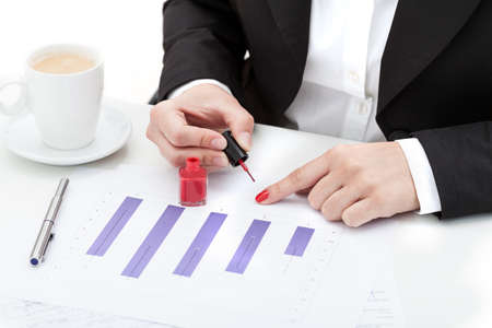 Break at work with coffee, woman doing her nailsの写真素材