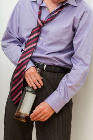 Drunk businessman with whisky trying to stand upの写真素材