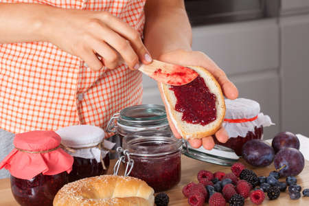 Housewife making sweet sandwiches with berry jam