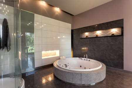 Round bath in a luxury tiled bathroom interiorの写真素材