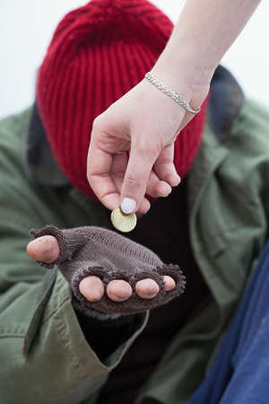 Women giving a coin for homeless poor manの写真素材