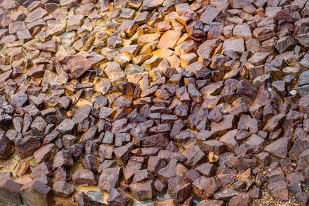 A dirty brown pebbly road with rays of the sunの写真素材