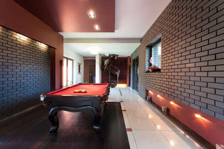 Snooker table in a luxury interior with brick walls