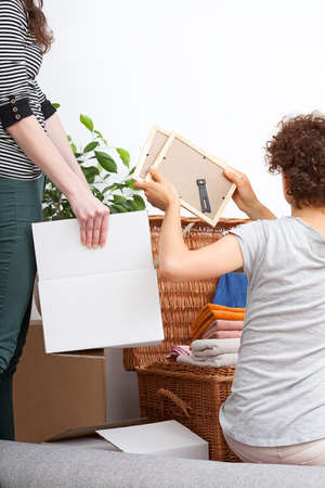 Young lesbian couple are packing useful things and moving out to new flat