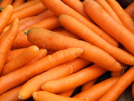 Close up of orange carrot pile presenting fresh vegetables