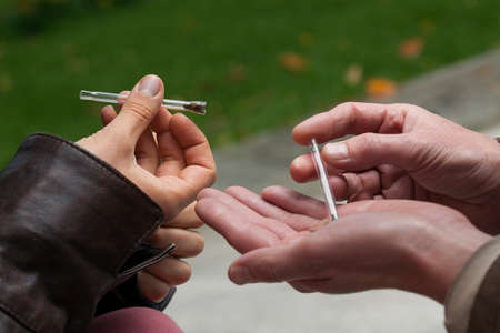 People addicted to marijuana holding a pipes