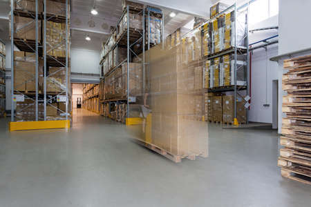 Spacious warehouse full of carton boxes on stillageの写真素材