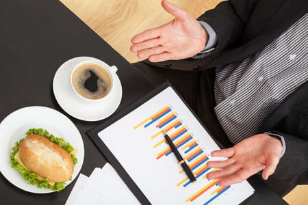 Businessman eating lunch at the office during workの写真素材