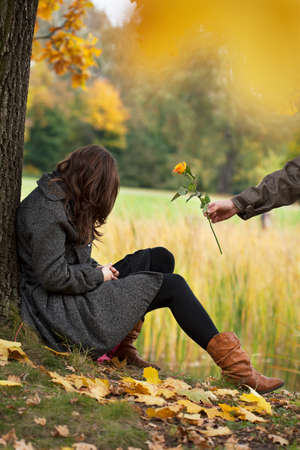 Young man apologizing girl after quarrel in parkの写真素材