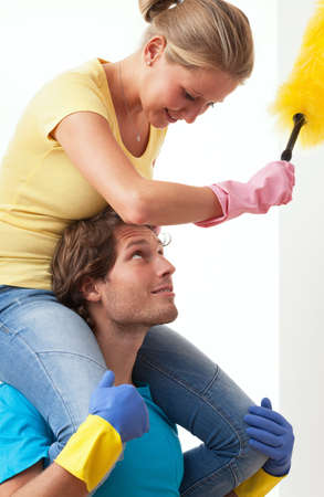 Enjoyment in housework, man carries his wife piggybackの写真素材
