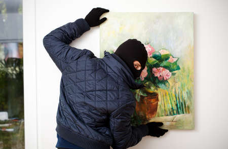 Thief stealing the piece of art from gallery of art の写真素材