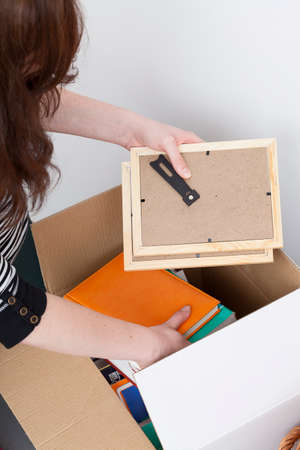 Woman packing photo frames into white box