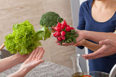 Friends showing a healthy green vegetables to promote eating themの写真素材