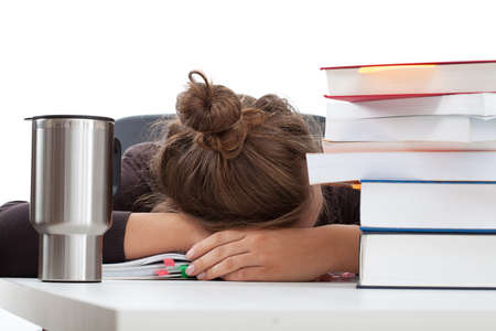 Exhausted student before an exam with stock of books
