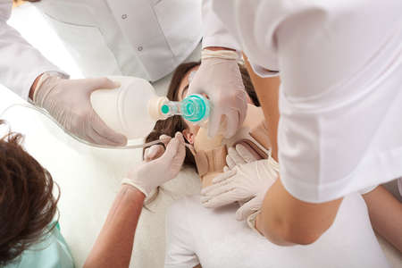Team of doctors and paramedics trying to bring back to life a dying woman. の写真素材