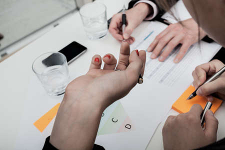 A close up of a woman's hand holding a pen