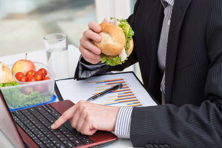 Quick business sandwich and vegetables at work in the officeの写真素材