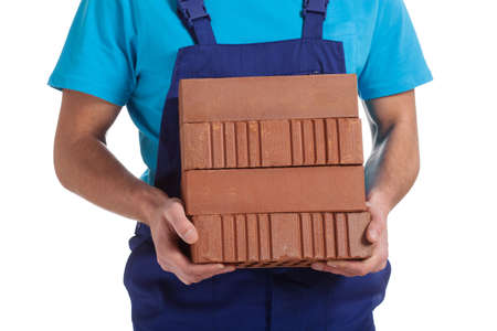 A closeup of a builder holding a pile of bricksの写真素材