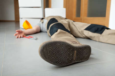 An exhausted worker lying on the floor having done his jobの写真素材