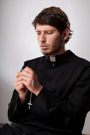 Cleric praying with a  rosary after confessionの写真素材