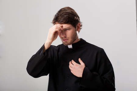 Priest wearing a soutane begining his prayer