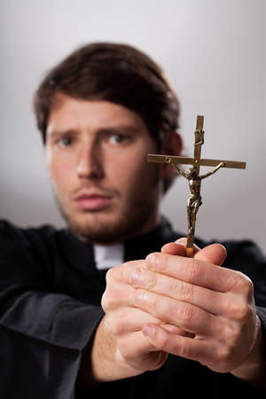 Exorcist holding a crucifix and making his prayersの写真素材