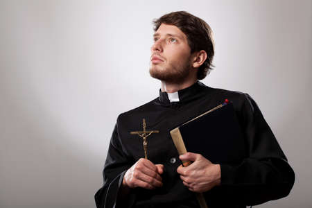 Vicar holding a holy bible and crucifixの写真素材