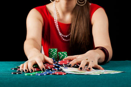 An elegant female gambler taking chips and banknotes