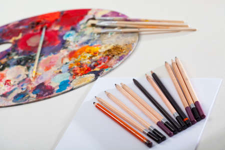 Table with drawing tools and dirty painting palette の写真素材