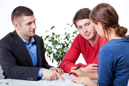 Couple signing the unfair mortgage agreement