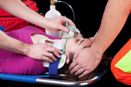 Two paramedics helping the casualty on a stretcher with a respiratorの写真素材