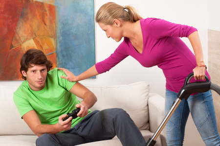 Woman who cleaning house is angry for her lazy partnerの写真素材