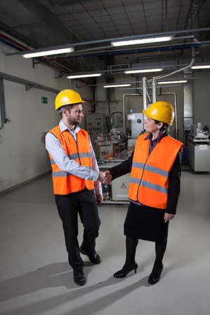 Workers in factory shaking hands to say thank you for cooperation