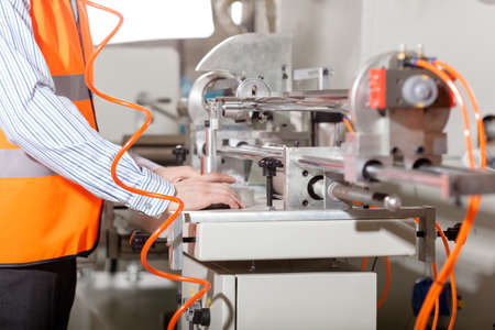 Factory worker operating lathe during production process