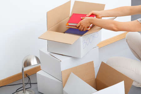 Plenty of cardboard boxes being filld by a man