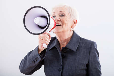 Elder woman screaming loud through the megaphoneの写真素材