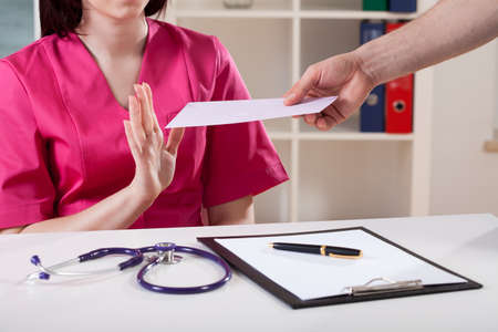 Doctor expressing disapproval for bribe at workの写真素材
