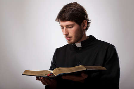 Young christian priest is reading the Holy Bibleの写真素材