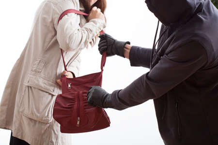 A thief taking a woman's bag off her shoulderの写真素材